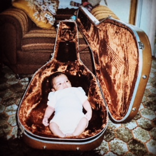 Musical youth: A young Darren relaxes in a guitar case