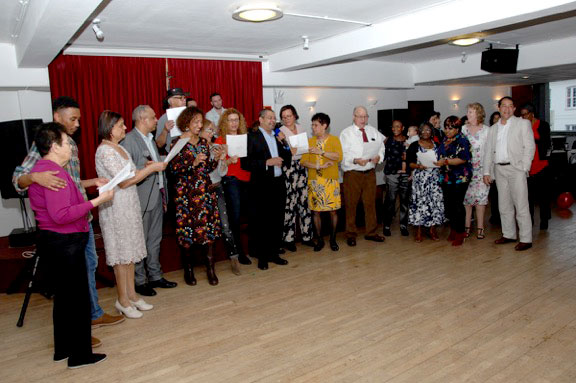 High note: High Commissioner Derick Ally, centre, leads the group singing for Isola Bella