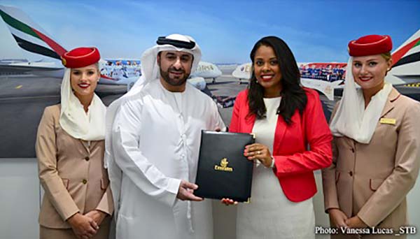 Agreement: Orhan Abbas of Emirates Airlines, centre, with Sherin Francis of the STB